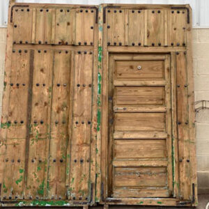 Portón antiguo de madera, con clavos. Compuesto de 2 hojas y puerta de paso. Medidas: 250 x 234 cm. Grosor de 7 cm.