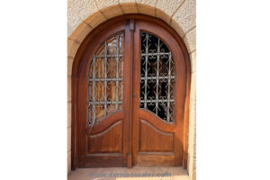 Puerta de calle, de madera maciza de mobila. Puerta con reja y cristal. Medidas: 220 x 173